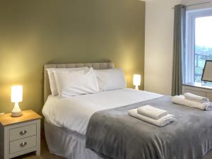 a bedroom with a bed with two towels on it at Shedfield Cottage in Drumnadrochit +5 photos