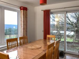 a dining room with a table and a large window at Shedfield Cottage in Drumnadrochit