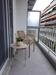 a balcony with two chairs and a table and a window at Twins Apartments 2 in Serres
