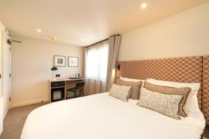 a bedroom with a white bed and a desk at Joivy Royal Mile Aparthotel in Edinburgh +52 photos