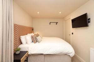a bedroom with a bed and a flat screen tv at Joivy Royal Mile Aparthotel in Edinburgh