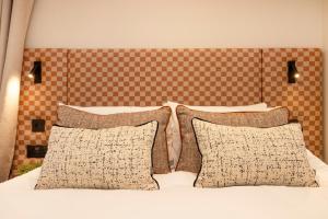 a bedroom with a bed with two pillows and a headboard at Joivy Royal Mile Aparthotel in Edinburgh