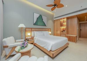 a bedroom with a bed and a table and chairs at Peninsula Del Mar Beach Resort in Udupi