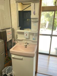 a bathroom with a sink and a refrigerator at Inn Unkai no Sato no Yado 民宿 雲海の里の宿 in Nosegawa