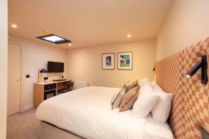 a bedroom with a white bed and a desk at Joivy Royal Mile Aparthotel in Edinburgh