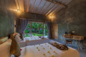 a bedroom with two beds and a window at Menjangan Dive Lodge in Banyuwedang