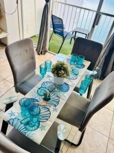 a table with blue glasses on top of a balcony at Suite Acapulco vista al mar in Acapulco +11 photos