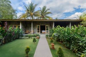a house with a garden in front of it at Menjangan Dive Lodge in Banyuwedang