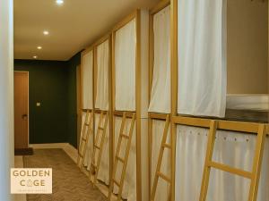 a row of curtains in a room with a bed at Golden Cage Heritage Hostel in Denpasar