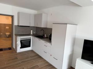 a kitchen with white cabinets and a stove top oven at Ferienwohnung -Alte Backstube- in Hadamar