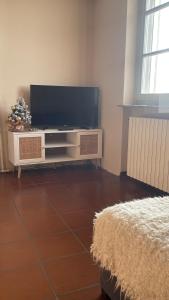a living room with a flat screen tv on a entertainment center at Ampio appartamento centro storico - Famiglie in Montalto Pavese
