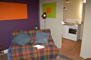 a living room with a couch and a kitchen at Crockers Farm in Dorking
