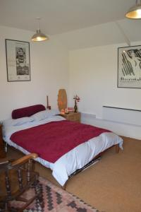 a bedroom with a bed with a red blanket at Crockers Farm in Dorking