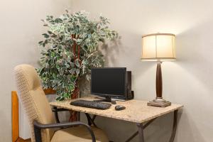 a desk with a lamp and a computer on it at Travelodge by Wyndham Owen Sound ON in Owen Sound