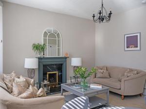 a living room with two couches and a fireplace at Lovely Little Let in Birnam