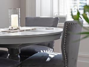 a table with chairs and a white table with a candle at Lovely Little Let in Birnam