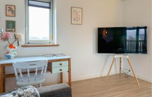 a living room with a desk and a tv on a wall at Nice Apartment In Hanstholm With Wifi in Hanstholm