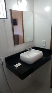 a bathroom with a white sink and a mirror at Pousada Viva Mar in Saquarema