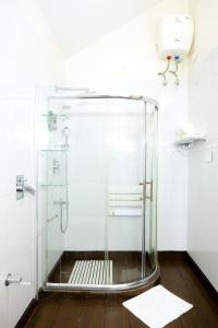 a shower with a glass door in a bathroom at Lynton Resorts in Kotagiri