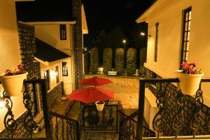 a red umbrella sitting on a balcony at night at Lynton Resorts in Kotagiri +28 photos