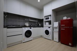 a kitchen with white appliances and a red refrigerator at Eunhasu D&M Residence in Daejeon