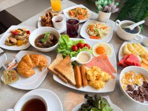 a table with many plates of food on it at Civic Horizon Hotel & Residence in Bangkok +66 photos