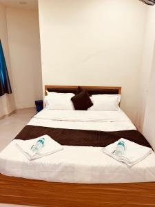 zwei Betten, die in einem Zimmer nebeneinander stehen in der Unterkunft Siya dormitory and rooms in Kolhapur + 10 Fotos