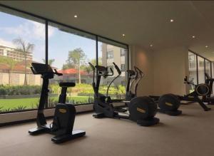 a gym with several tread machines and a large window at Urban Nook, The Bantree in Accra