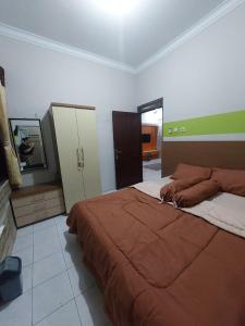 a bedroom with a large bed in a room at Clara Guest House in Seturan