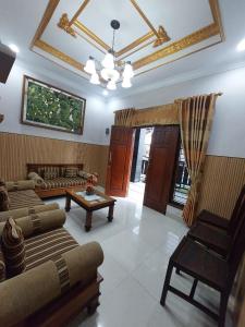 a living room with couches and a table and a ceiling at Clara Guest House in Seturan