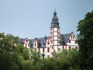 a large building with a clock tower on top of trees at Ferienwohnung -Alte Backstube- in Hadamar