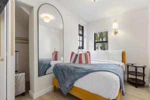 a bedroom with a bed and a mirror at Jefferson Avenue Suites in Miami Beach +29 photos