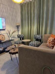 a living room with a couch and two chairs at Serene Sidai in Nairobi