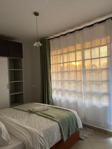 a bedroom with a bed in front of a window at Serene Sidai in Nairobi +18 photos