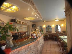 a restaurant with a bar with tables and chairs at Restaurant-Hotel Dimitra in Alsbach-Hähnlein