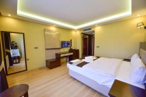 a bedroom with a bed and a desk and a mirror at Dogramaci Hotel City in Tosya
