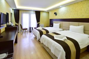 a hotel room with two beds and a desk at Dogramaci Hotel City in Tosya +7 photos