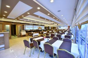 a banquet hall with tables and chairs in a restaurant at Dogramaci Hotel City in Tosya