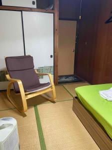 a room with a chair next to a bed at Adventure Hostel う島や in Iriomote +19 photos