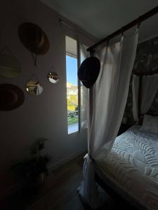 a bedroom with a canopy bed and a window at Suite Eden Jungle - Ambiance tropicale cosy in Limoges