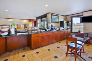 a restaurant with a counter and a table and chairs at Quality Inn Marshall near I-69 in Marshall