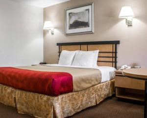 a bed in a hotel room with a red blanket on it at Econo Lodge Inn & Suites Colonie Center Mall in Albany