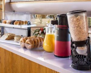 a counter with a blender and a bunch of pastries at Econo Lodge Inn & Suites Colonie Center Mall in Albany +19 photos