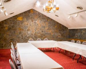a room with tables and chairs and a stone wall at Econo Lodge Inn & Suites Colonie Center Mall in Albany