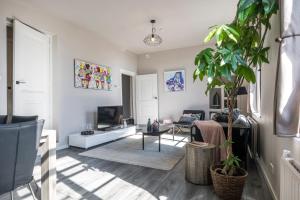 a living room with a potted plant in it at The Carriage House - Historic 3-Bedroom Apartment near Utrecht - Huize de Lekpoort Vianen in Vianen
