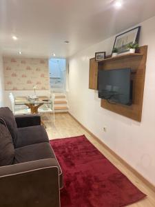 a living room with a couch and a flat screen tv at Vida Entre Balcones in Combarro