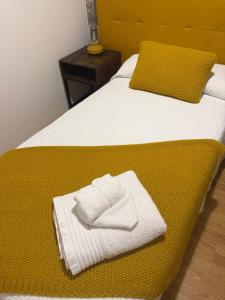 a bed with two towels sitting on top of it at Vida Entre Balcones in Combarro
