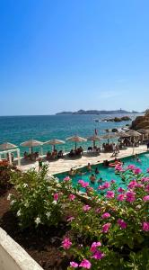 a group of people in a swimming pool next to the ocean at Suite Acapulco vista al mar in Acapulco