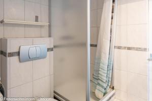 a shower with a glass door in a bathroom at Ankerplatz 607 in Schilksee +24 photos