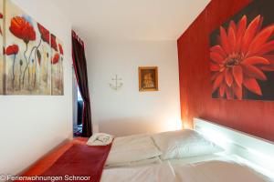 a bedroom with a bed with a flower painting on the wall at Ankerplatz 607 in Schilksee